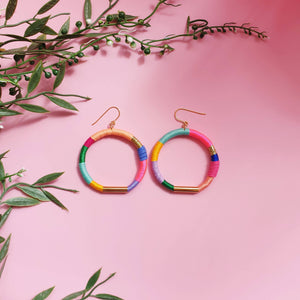 Colorful hoop earrings wrapped in pastel and bold thread with gold-tone accents