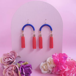 Vibrant handmade earrings with striking blue arches and bright orange tassels, perfect for a pop of colour!