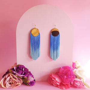 Hand-dyed blue ombre tassel earrings with a gold-plated pendant, featuring a vibrant, lightweight, and elegant design.