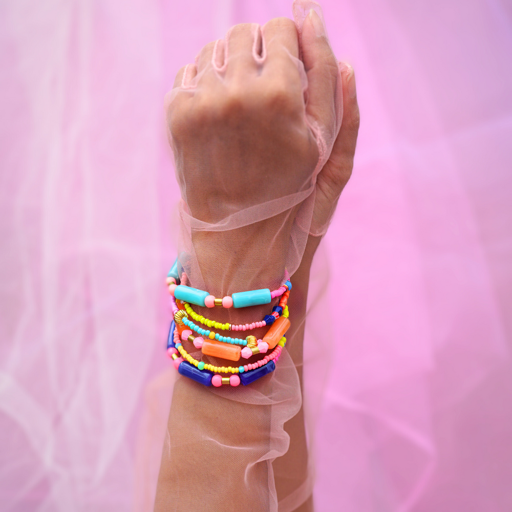 Display of green, peach, and orange beaded bracelets, showcasing their vibrant and colourful designs with a lively mix of beads and accents.