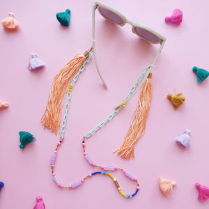 A statement accessory with mint green links and lilac beads, offering versatility as a sunglasses chain, necklace, or lanyard. The gentle colour combination, accented by flowing tassels, makes it both eye-catching and practical.