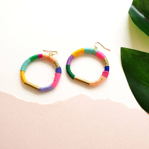 Colorful hoop earrings wrapped in pastel and bold thread with gold-tone accents