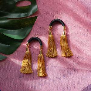 Trendy black and gold tassel earrings with a unique arched design, featuring silky gold tassels that sway with every movement.