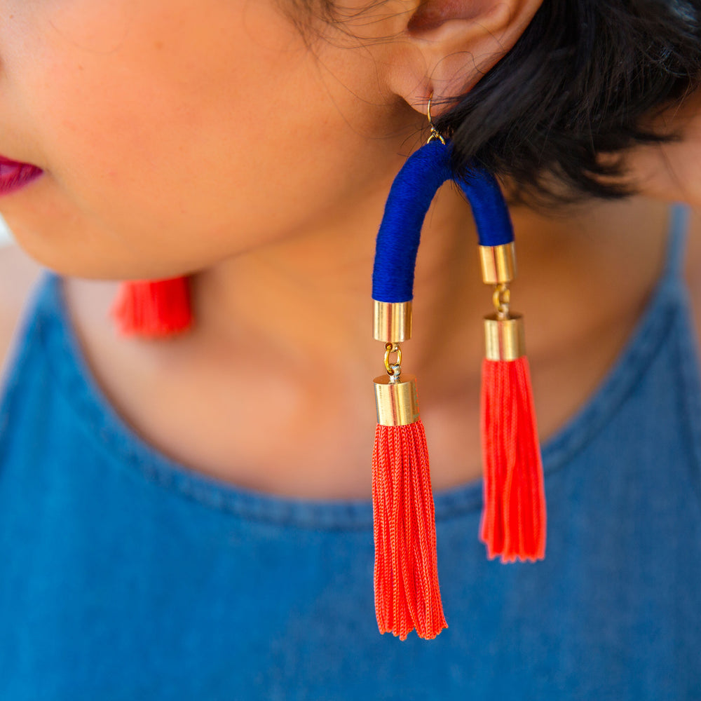 Vibrant handmade earrings with striking blue arches and bright orange tassels, perfect for a pop of colour!