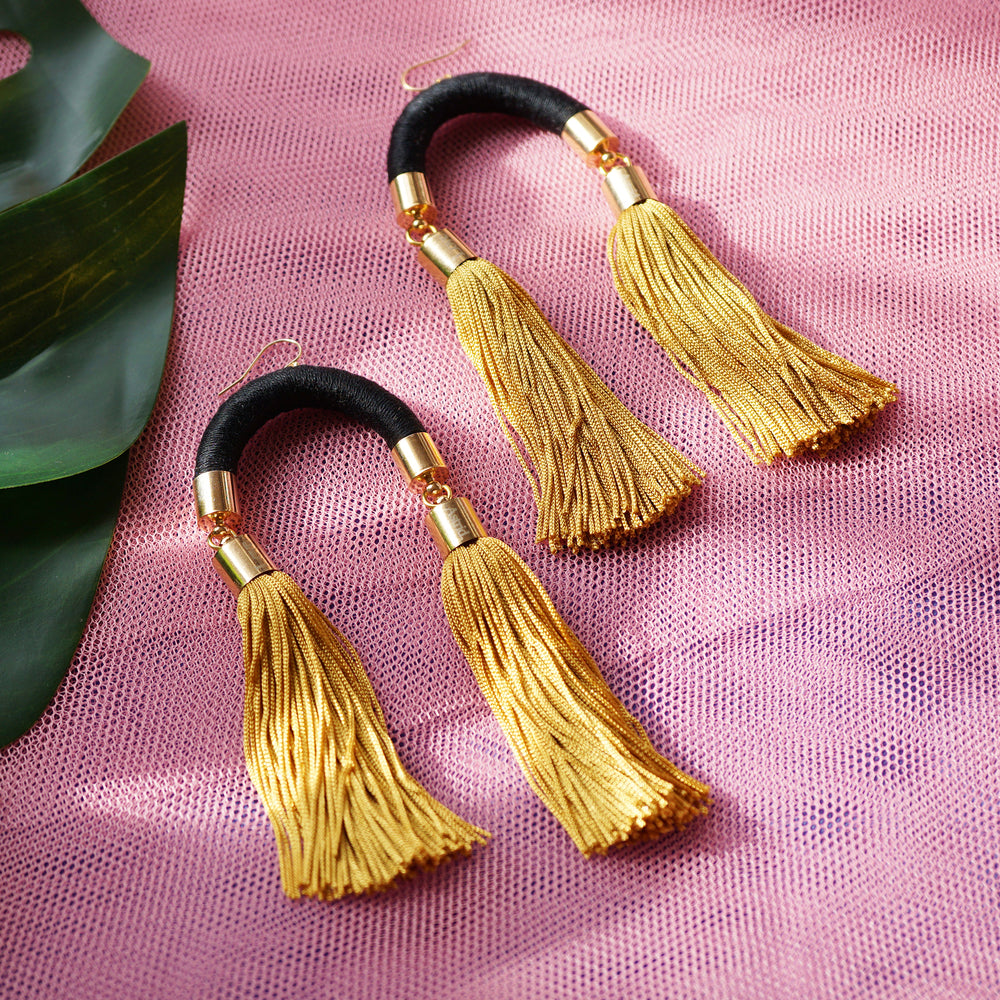 Trendy black and gold tassel earrings with a unique arched design, featuring silky gold tassels that sway with every movement.