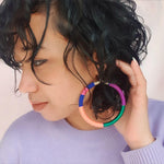 Model wearing lightweight, vibrant earrings, showcasing their bold and colorful design.