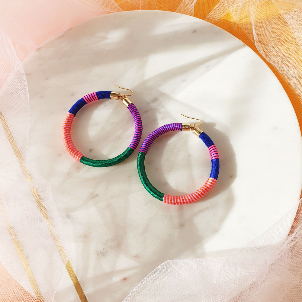 Colourful bold hoops earrings wrapped in a vibrant combination of emerald green, navy blue, orange, peach, and pink for a striking, vibrant and bold look.