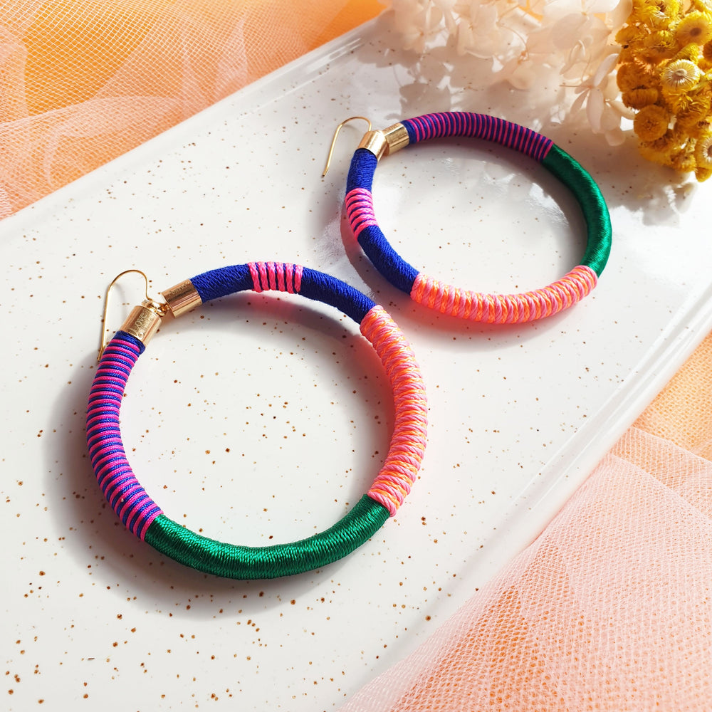 Colourful bold earrings wrapped in a vibrant combination of emerald green, navy blue, orange, peach, and pink for a striking, bold and vibrant look.