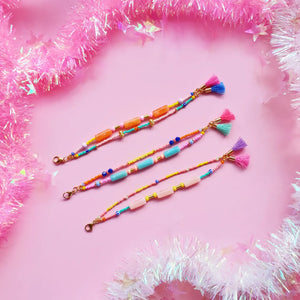 Display of green, peach, and orange beaded bracelets, showcasing their vibrant and colourful designs with a lively mix of beads and accents.