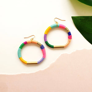 Colorful hoop earrings wrapped in pastel and bold thread with gold-tone accents